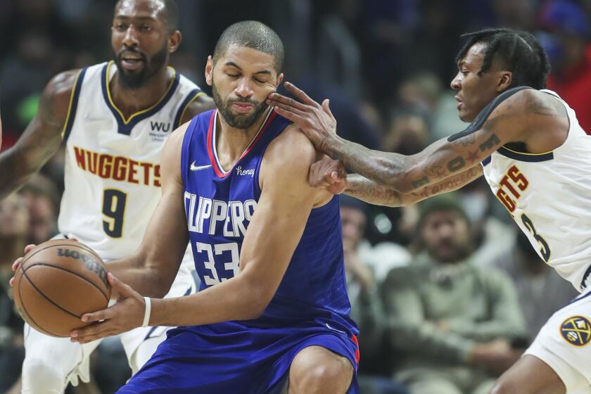 Los Angeles, CA - January 11: Clippers forward Nicolas Batum, center, gets fingers in the face.