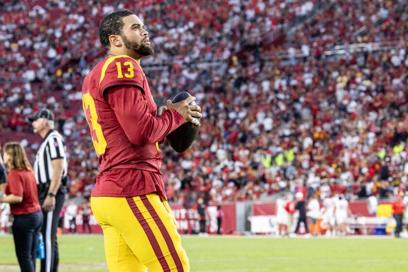 USC quarterback Caleb Williams looks up at the scoreboard while staying loose during a timeout 