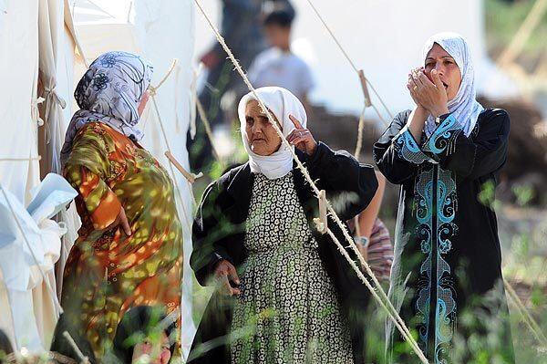 Syrian refugee women chat at the Turkish Red Crescent camp near the Syrian border.