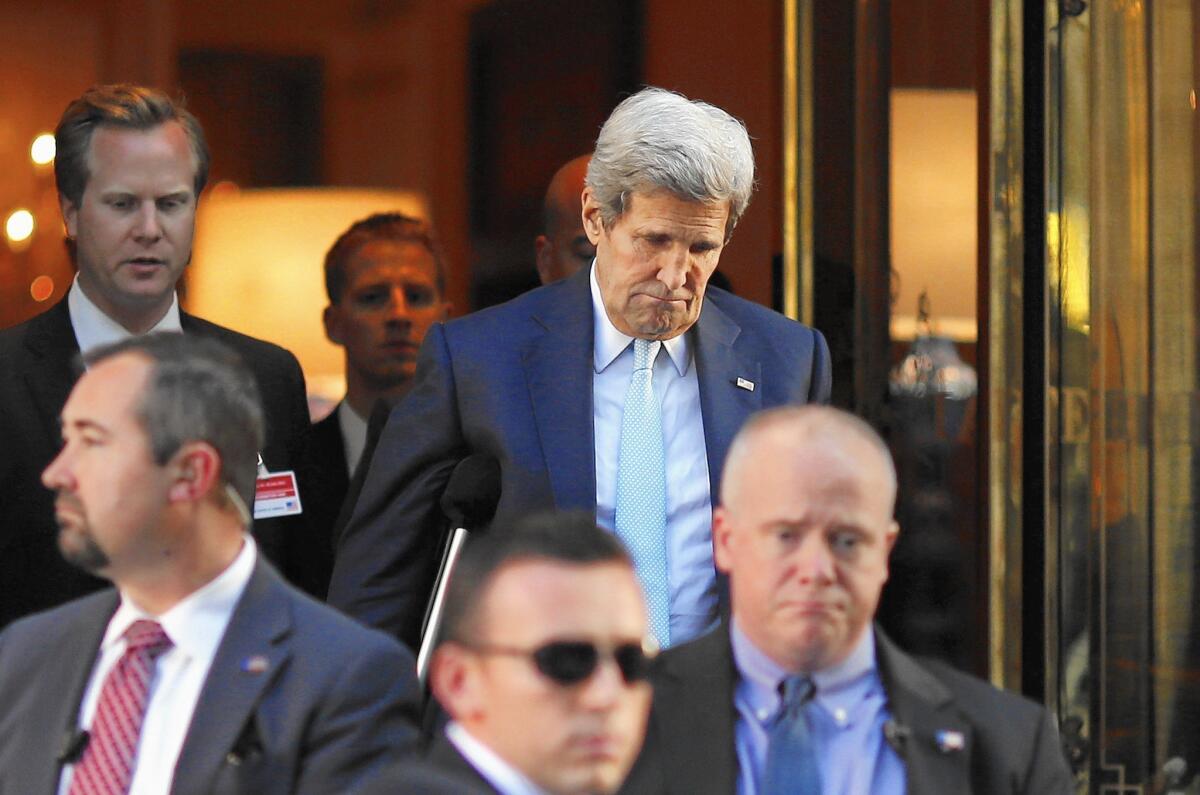 U.S. Secretary of State John F. Kerry, rear right, leaves his hotel for a meeting with Iranian Foreign Minister Mohammad Javad Zarif in Vienna.