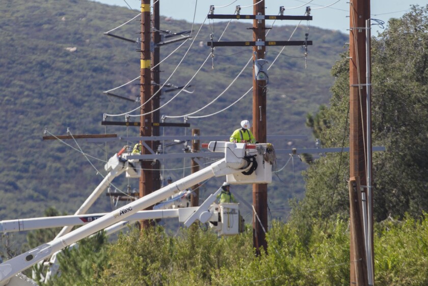 Utility construction crews work to replace wooden power poles with a system of fireproof steel structures on Viejas Blvd. between Highway 79 and Descanso on Wednesday, Oct. 9, 2019.
