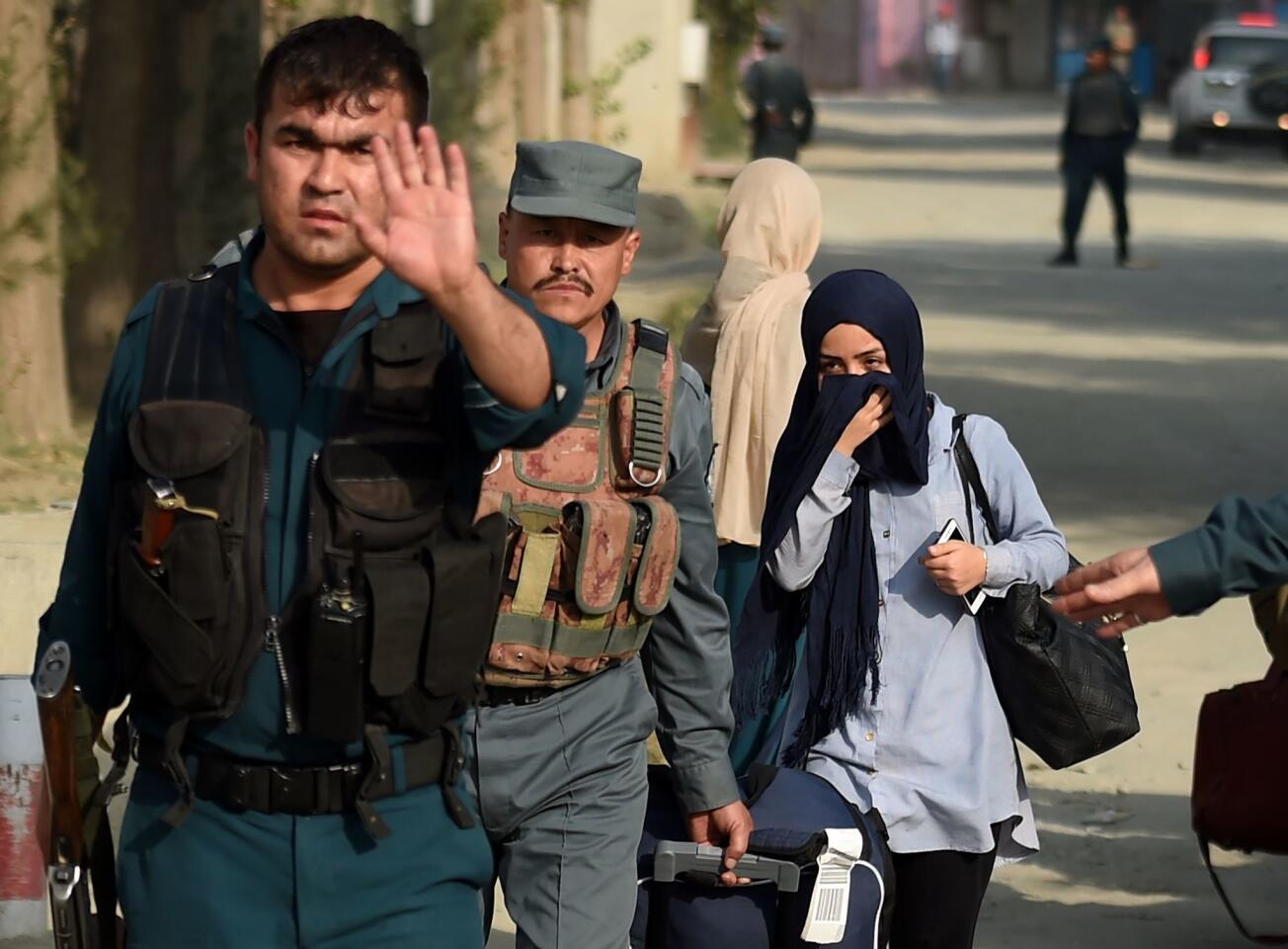 Afghan students from the American University are escorted by police forces at the end of a nearly 10-hour raid in Kabul, Afghanistan on August 25, 2016.
