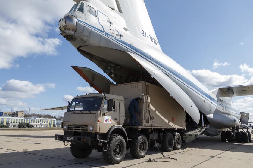 FILE - In this March 22, 2020 file photo distributed by Russian Defense Ministry Press Service, a military truck loads medical supplies for Italy on a board of an Il-76 cargo plane in Chkalovsky military airport outside Moscow, Russia. From tiny San Marino wedged next to two of Italy's hardest-hit provinces in the coronavirus outbreak to more economically powerful nations like Italy, countries are running up against export bans and seizures in the scramble for vital medical supplies. The new coronavirus causes mild or moderate symptoms for most people, but for some, especially older adults and people with existing health problems, it can cause more severe illness or death. (Alexei Yereshko, Russian Defense Ministry Press Service via AP)