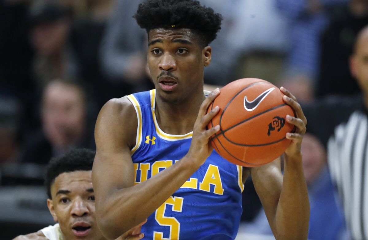 UCLA guard Chris Smith tries to drive to the basket in front of Colorado guard Tyler Bey during the first half of the Bruins' 70-63 victory Saturday.