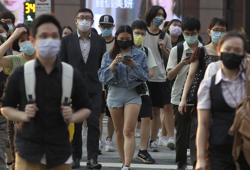 FILE - People wear face masks to help protect against the spread of the coronavirus in Taipei, Taiwan, Thursday, Sept. 30, 2021. Taiwan has recorded its first case of the omicron variant in a passenger who returned from Eswatini, the southern African kingdom, on Dec. 8, according to the island's health officials. (AP Photo/Chiang Ying-ying, File)