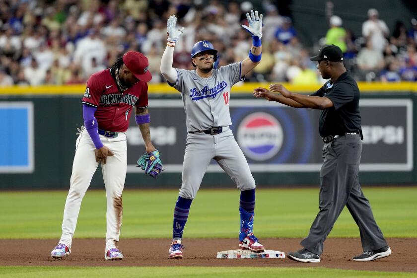 Miguel Rojas (11), de los Dodgers de Los Ángeles, celebra su doble en contra de los Diamondbacks de Arizona, durante la octava entrada del juego de béisbol, el lunes 29 de abril de 2024, en Phoenix. (AP Foto/Matt York)