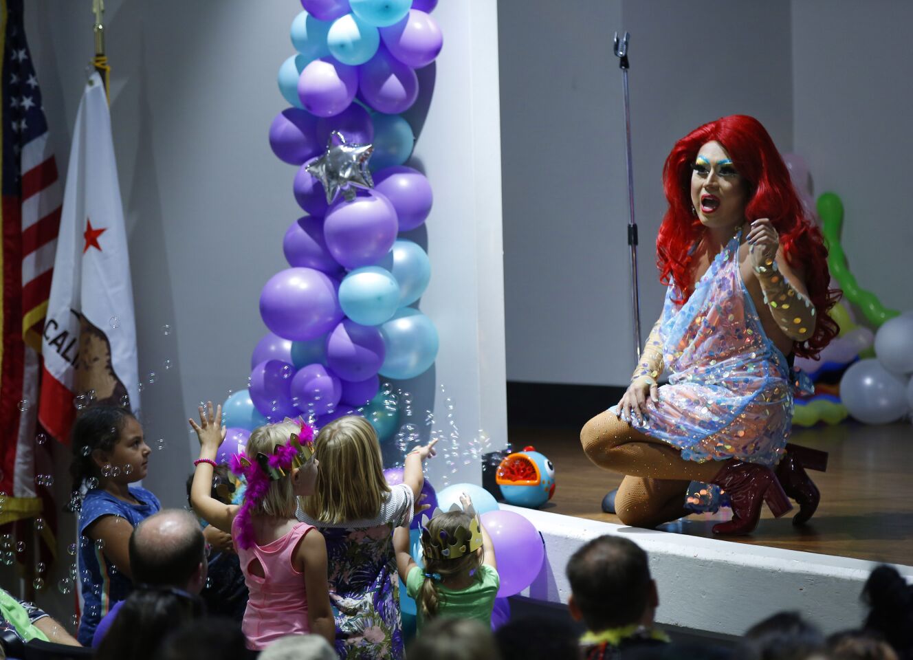 Raquelita, a drag queen, sings a song from the Little Mermaid during Drag Queen Story Time at the Chula Vista Civic Center Library on Sept. 10, 2019.