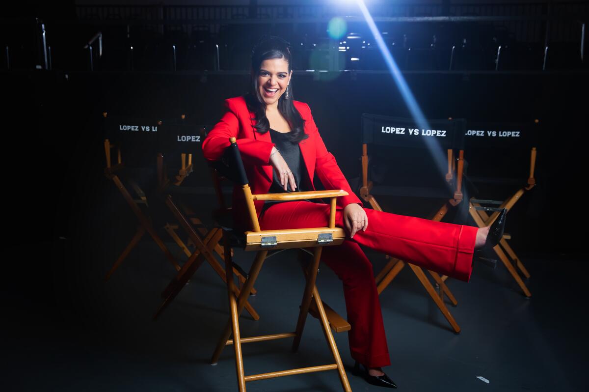 Mayan Lopez laughs while posing for a portrait sitting in a director's chair.