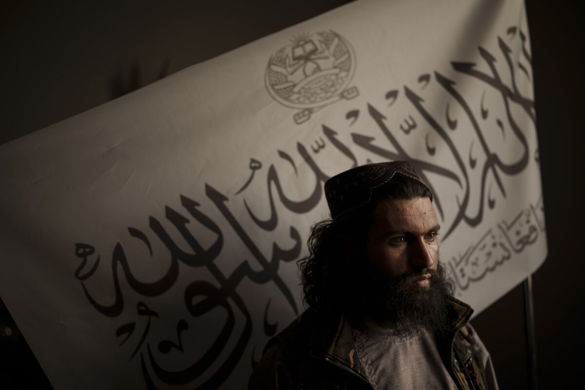 FILE - In this Sept. 20, 2021 file photo, Taliban district police chief Shirullah Badri stands in front of a Taliban flag during an interview at his office in Kabul, Afghanistan. The Islamic State in Afghanistan, emerged in 2015 when the group was at it's peak, controlling vast swathes of territory in Iraq and Syria. Now, with the U.S. exit from Afghanistan, IS is poised to usher in another violent phase - except this time it is the Taliban playing the the role of the state. (AP Photo/Felipe Dana, File)