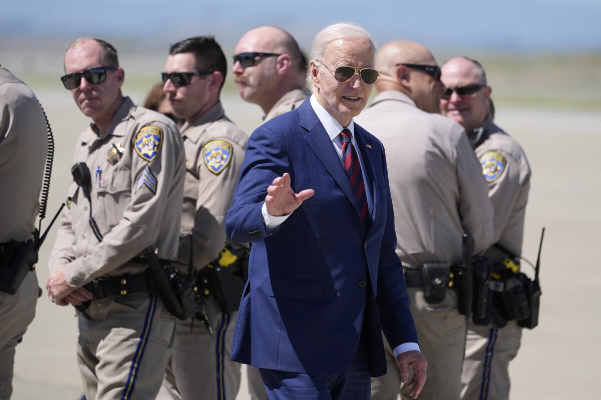 President Biden waves as he walks past law enforcement officers