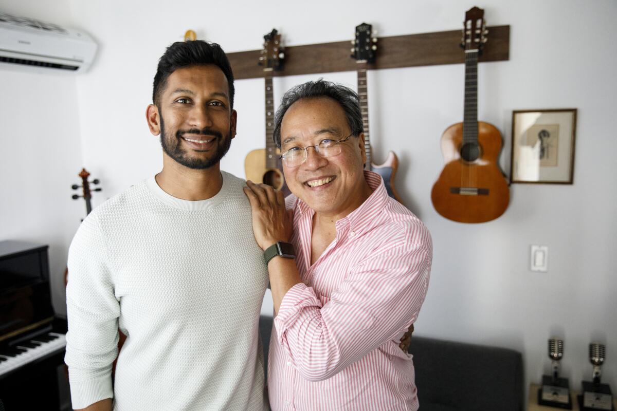 Hrishikesh Hirway, left, founder of the "Song Exploder" podcast, and cellist Yo-Yo Ma pause in Hirway's home studio in Los Angeles.
