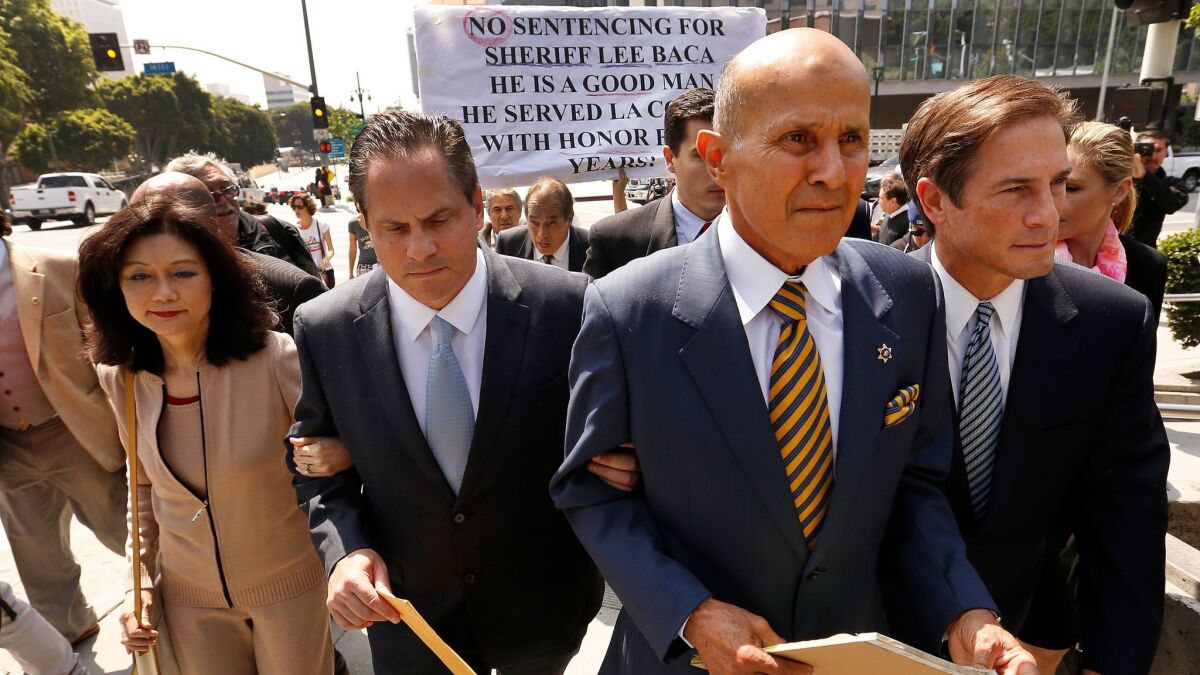 Former Los Angeles County Sheriff Lee Baca, second from right, leaves a downtown courthouse Friday after being sentenced to three years in prison for his role in a 2011 plan to obstruct an FBI investigation into county jails. (Al Seib / Los Angeles Times)
