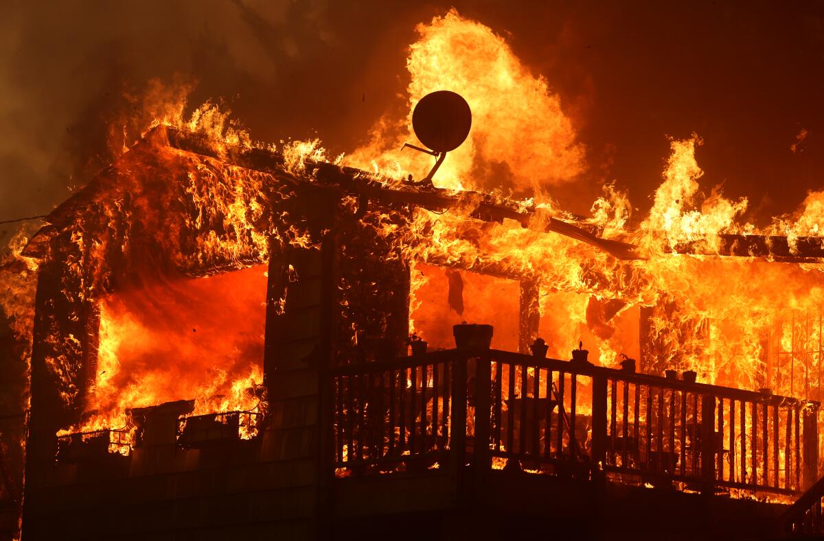 A photo of a house burning from the Airport Fire in El Cariso Village along Ortega Highway Tuesday.