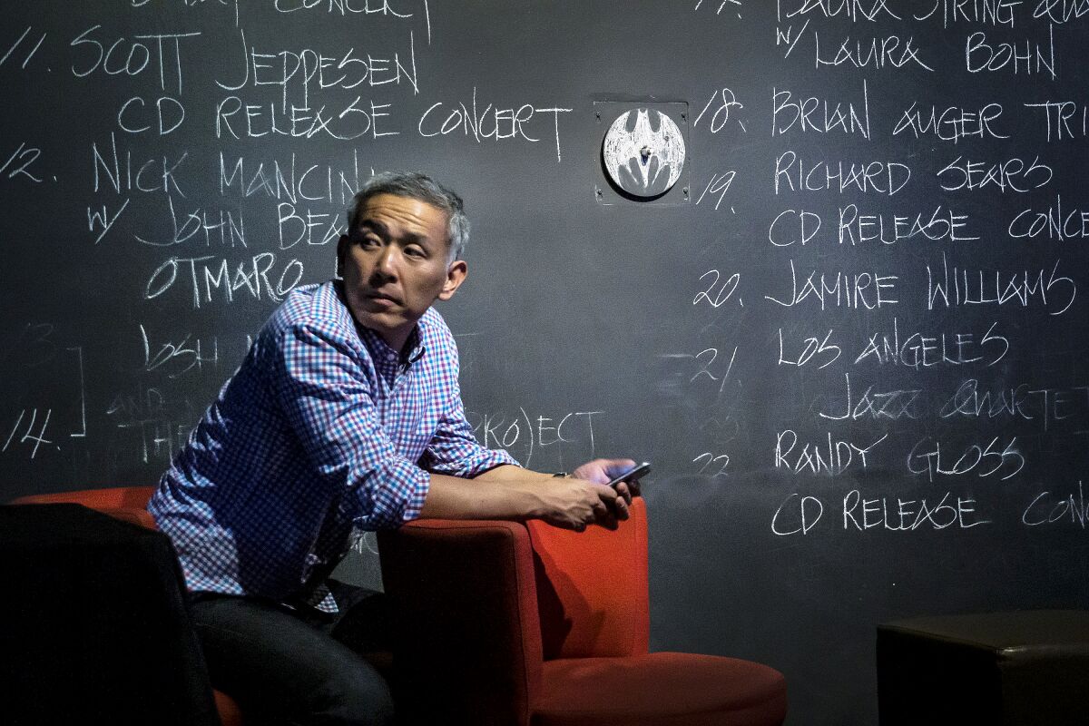 Joon Lee, owner of Blue Whale, in front of the club's iconic chalkboard.