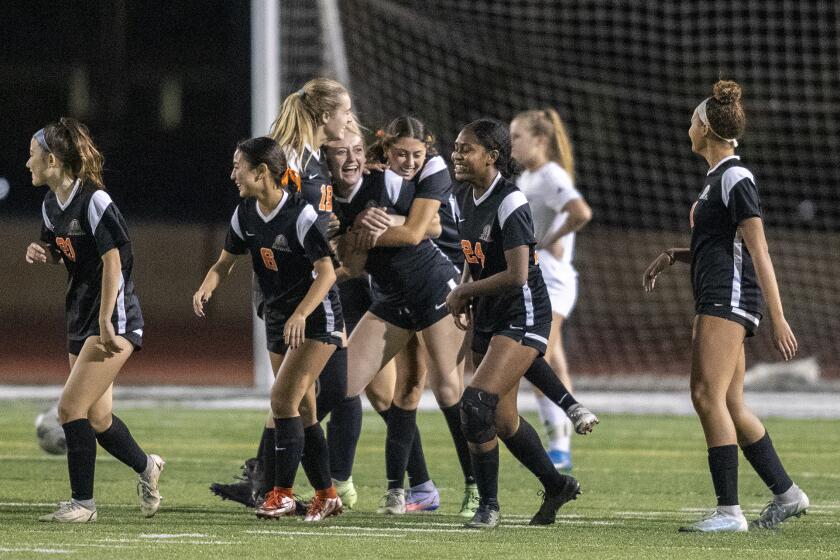 Huntington Beach teammates mob Kyley Asheim after she scores a goal against Corona del Mar's during a Surf League game on Tuesday, January 11.