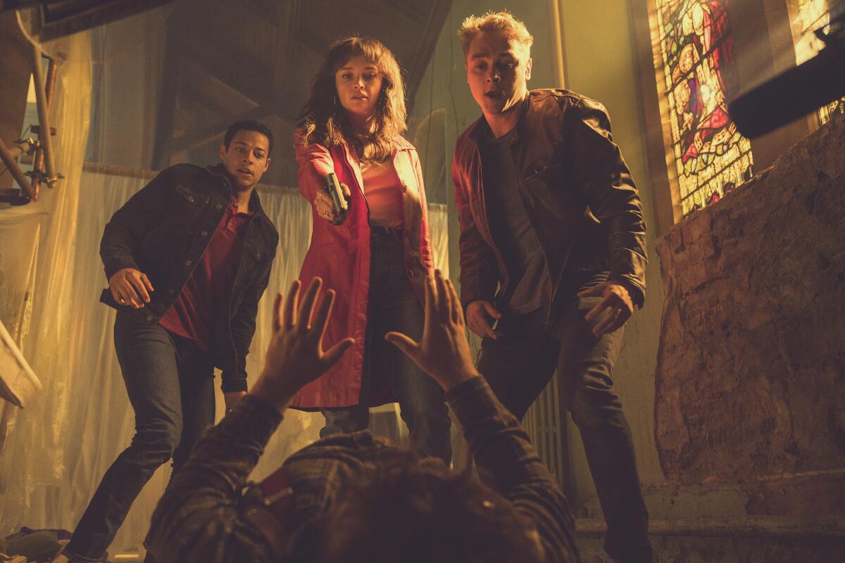 Olivia Cooke, Daryl McCormack and Ben Hardy stand over a man lying on the floor