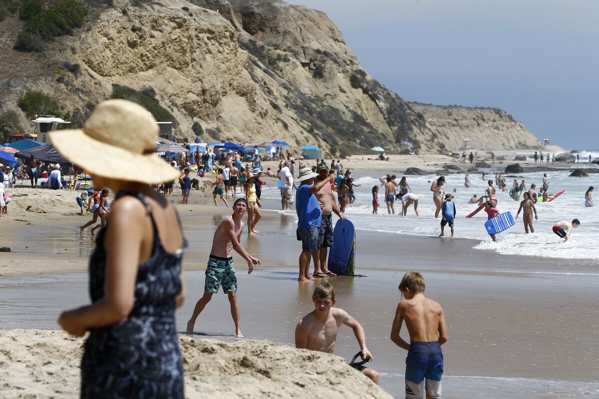 Beachgoers enjoy the sunshine and water at Crystal Cove State Beach. 