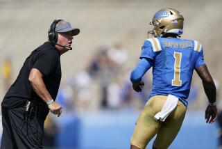 UCLA coach Chip Kelly talks to UCLA quarterback Dorian Thompson-Robinson during a game 