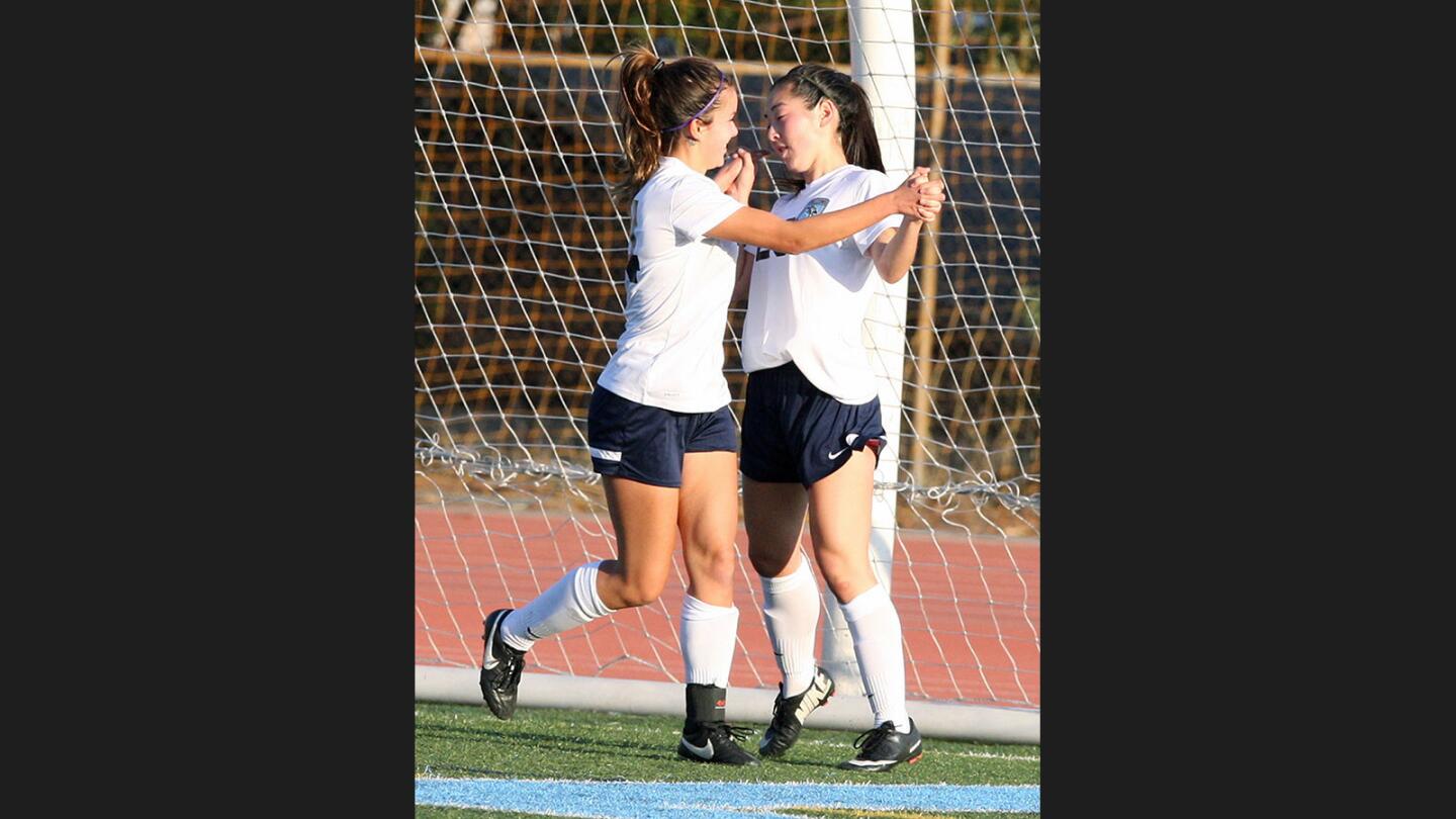 Crescenta Valley's Nikki Collins runs to Crescenta Valley's Nicole Yim after she scored the first goal of the game in a Pacific League girls' soccer game at Crescenta Valley High School on Friday, December 9, 2016.