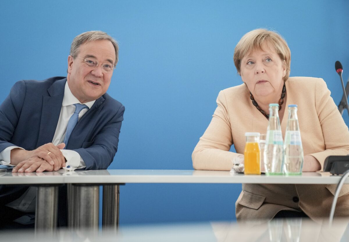 Armin Laschet, left, candidate for Chancellor of Germany's center-right block and Christian Democratic Union chairman talks with Chancellor Angela Merkel during a CDU party's executive meeting in Berlin, Germany, Monday, Sept. 13, 2021. (Kay Nietfeld/dpa via AP)