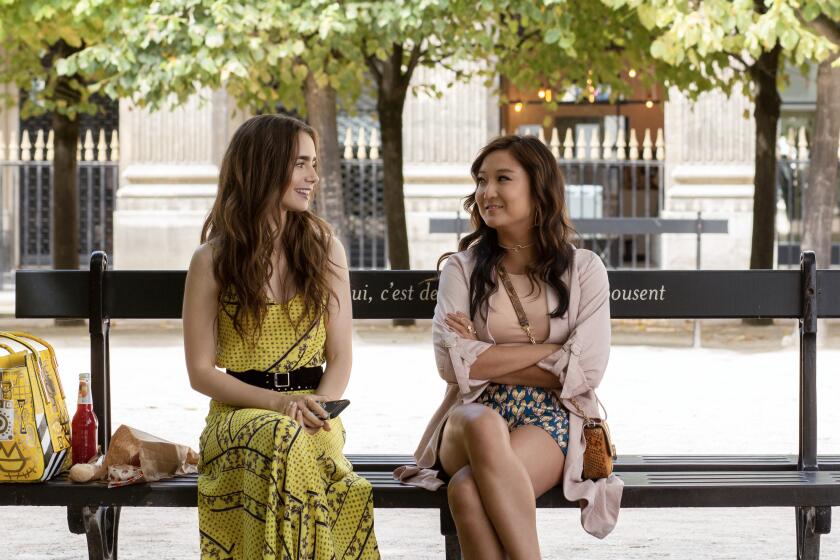 EMILY IN PARIS (L to R) LILY COLLINS as EMILY and ASHLEY PARK as MINDY CHEN in episode 101 of EMILY IN PARIS. Cr. CAROLE BETHUEL/NETFLIX ? 2020