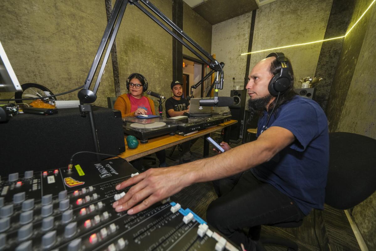 Three radio hosts in a studio.