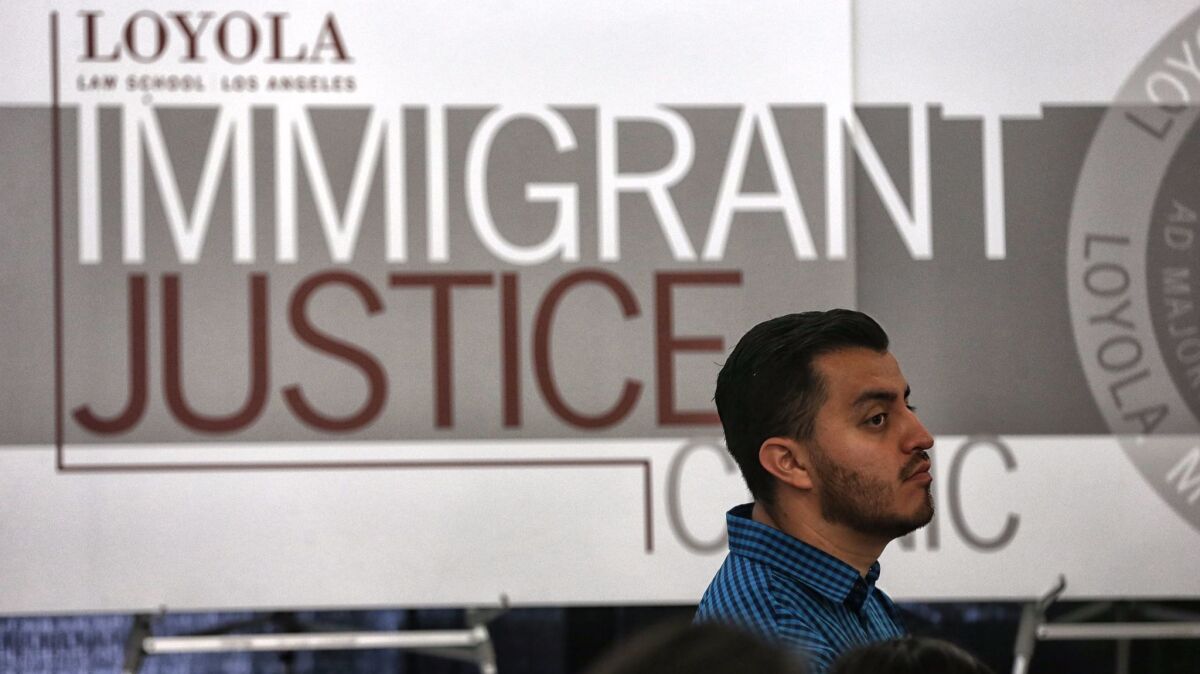 Christian Perez, 30, consults with volunteers at the Loyola Immigrant Justice Clinic at Loyola Law School to process a DACA renewal.