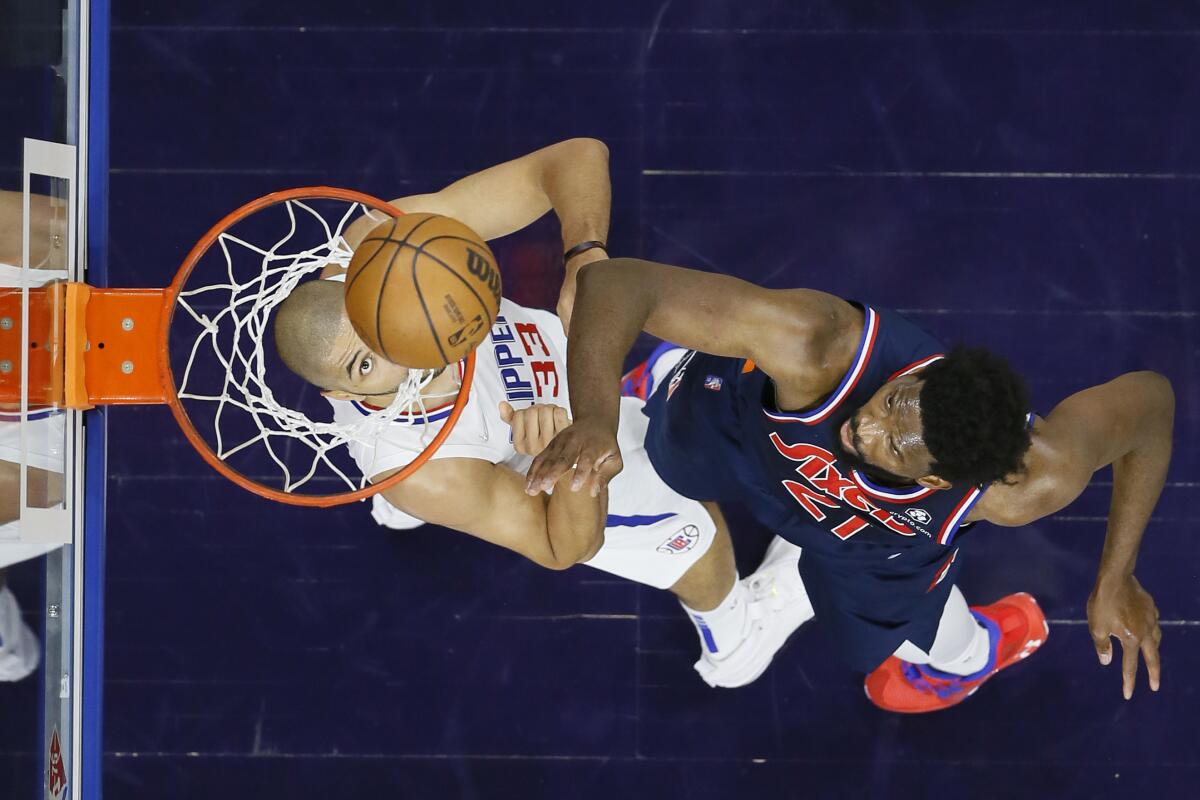 76ers center Joel Embiid goes up for a shot over Clippers forward Nicolas Batum.