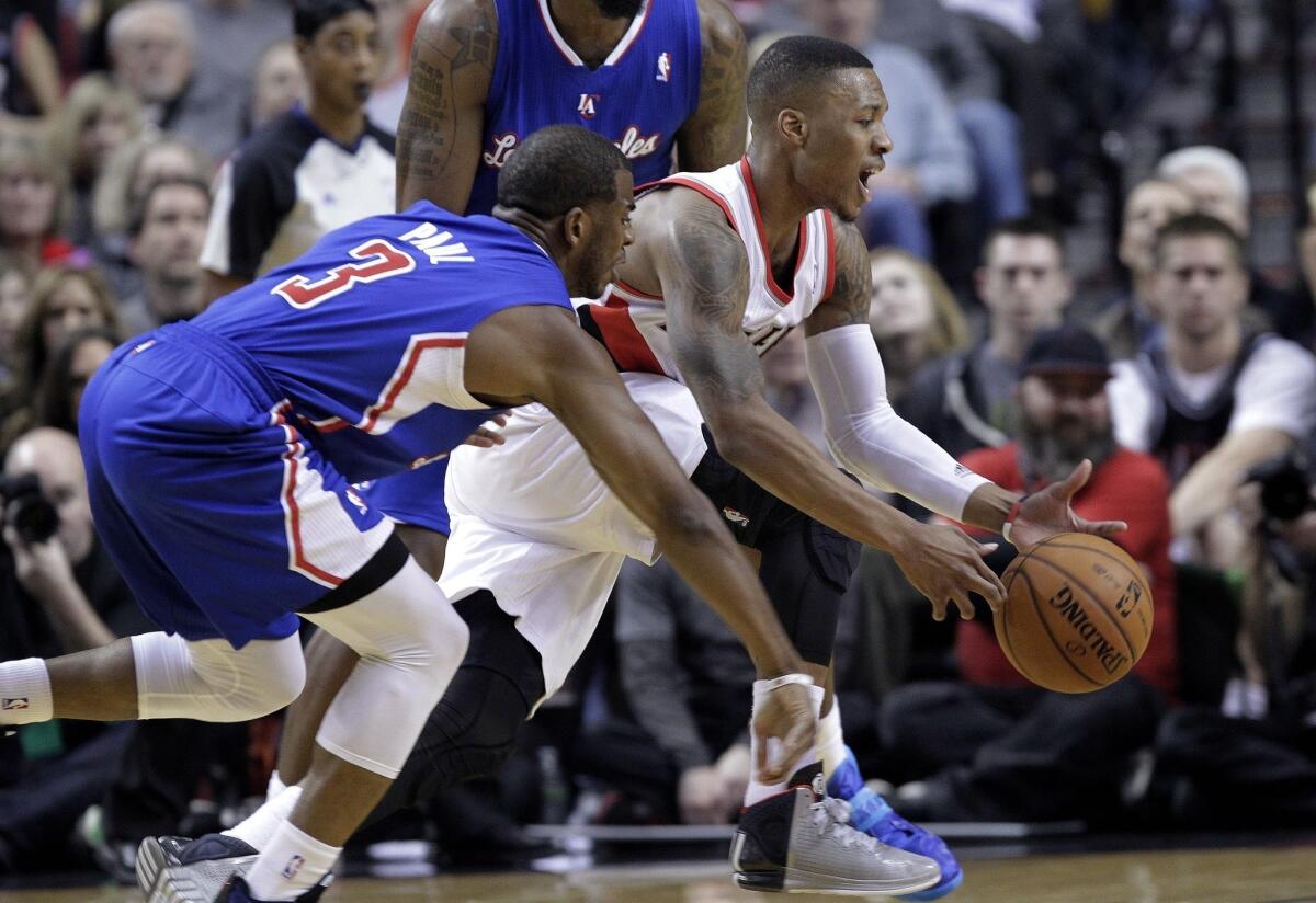 Clippers point guard Chris Paul knocks the ball from Trail Blazers guard Damian Lillard in the first half Thursday night in Portland.