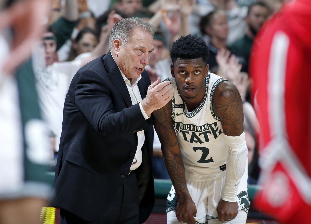 Michigan State coach Tom Izzo, left, talks with Rocket Watts during the second half of an NCAA college basketball game against Ohio State, Sunday, March 8, 2020, in East Lansing, Mich. (AP Photo/Al Goldis)