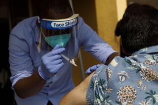 A healthcare worker wearing a protective mask and face shield administers a free flu shot vaccination to a patient at a YMCA location in Los Angeles, California, U.S., on Saturday, Sept. 26, 2020. The annual U.S. flu vaccine campaign has been cast into disarray by Covid-19, with people staying away from pharmacies, schools, offices, hospitals and other places where they typically get their shots. Photographer: Patrick T. Fallon/Bloomberg via Getty Images