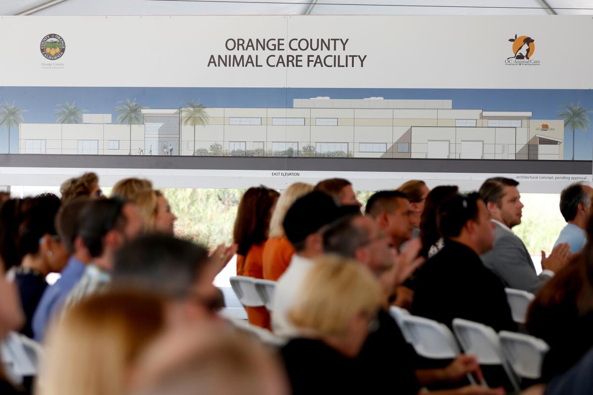 Guests sit below a rendering of the proposed new Orange County Animal Care Shelter at a groundbreaking ceremony on the former Tustin Marine Corps Air Station.