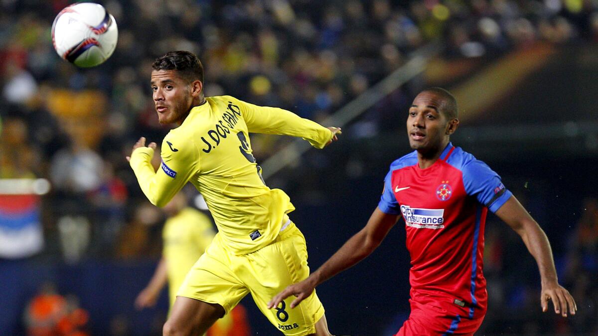 Villarreal midfielder Jonathan dos Santos heads a pass forward in front of Steaua Bucharest midfielder William de Amorim during the UEFA Europa League game Dec. 8.