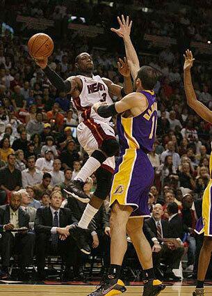 Miami Heat guard Dwyane Wade passes off as the Lakers' Vladimir Radmanovic defends Friday night in Miami.