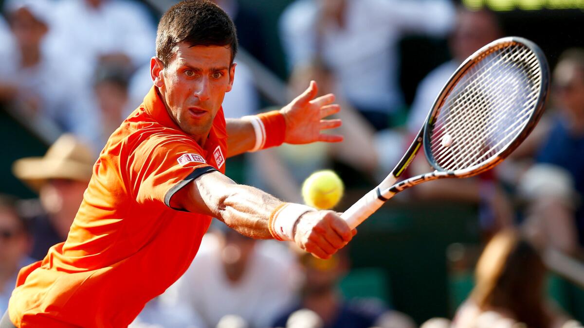 Novak Djokovic reaches for a volley during his French Open semifinal match against Andy Murray on Friday.