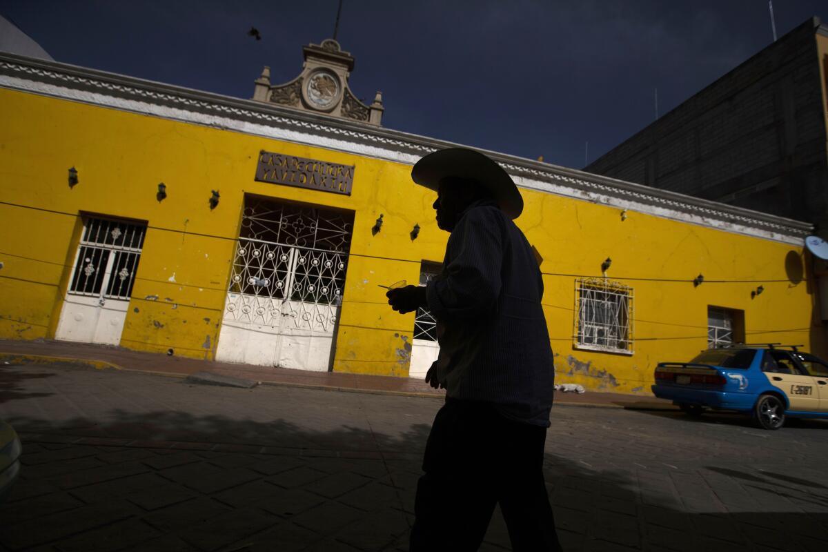 Un cliente sale de un banco en Acatlán de Osorio, México, en 2020.