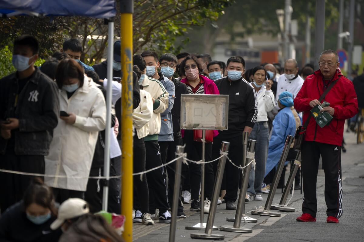 People stand in line for coronavirus tests at a coronavirus testing site.