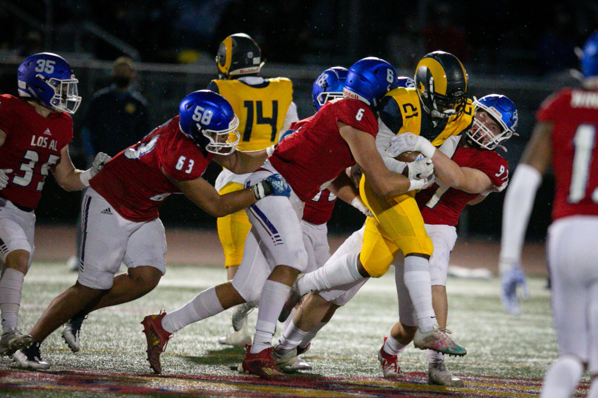 Los Alamitos defenders bring down Millikan running back Ajae Gravelly.