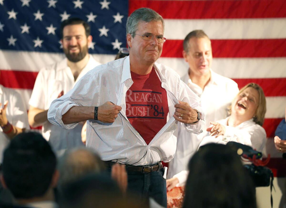 Republican presidential candidate and former Florida Governor Jeb Bush shows off a Reagan/Bush '84 tee-shirt as he speaks during a Miami field office opening on Sept 12.