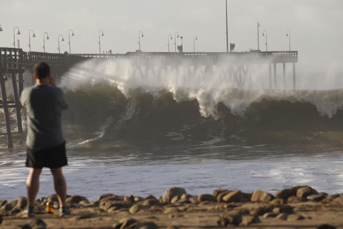 David Volk of San Francisco watches the Ventura Pier get pounded by heavy surf Jan. 7 as El Niño storms move through Southern California.