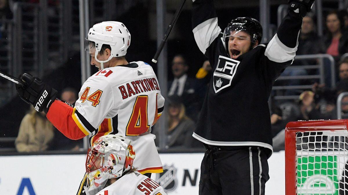 Kings right wing Dustin Brown, right, celebrates a goal by center Anze Kopitar as Calgary Flames defenseman Matt Bartkowski, upper left, and goalie Mike Smith look on during the second period on Oct. 11.