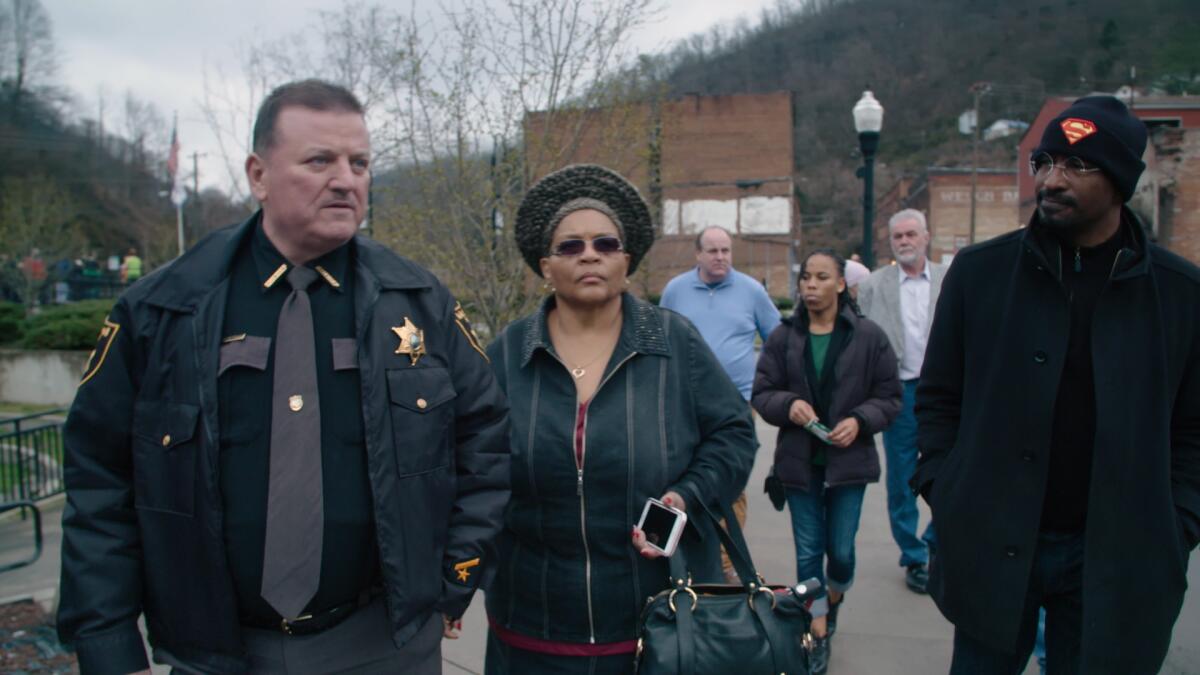The white sheriff of Welch, W.Va., walks with a Black TV commentator and a leader of an L.A. substance-abuse services group.