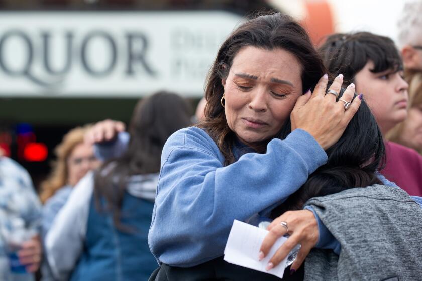 Glori Smiley embraces loved ones mourning the death of her daughter, Rosenda Elizabeth Smiley.