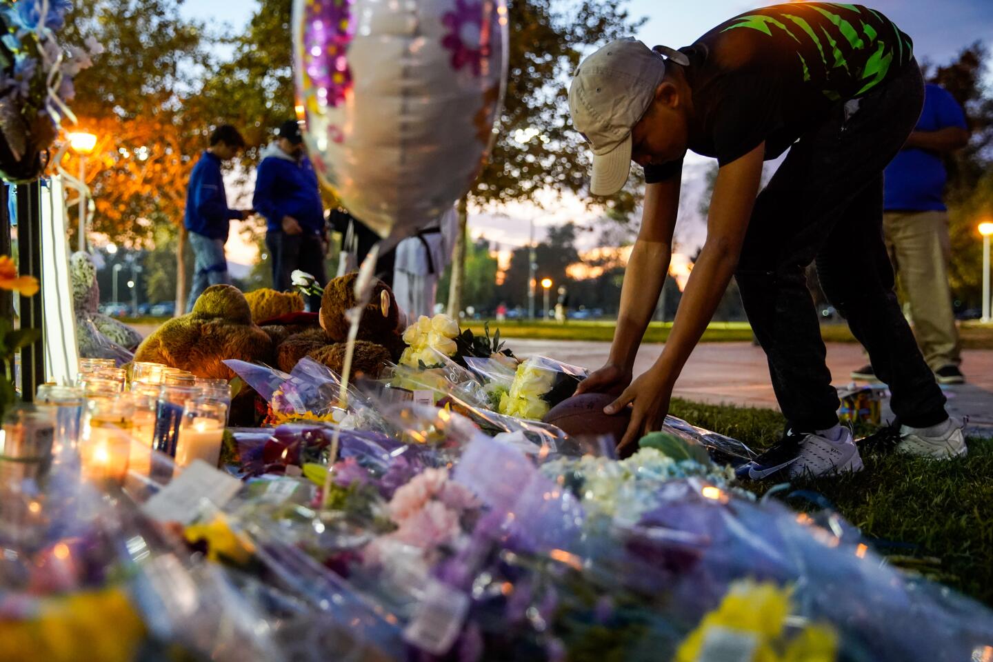 Sebastian Martinez, 12, places a football at the memorial in Santa Clarita.