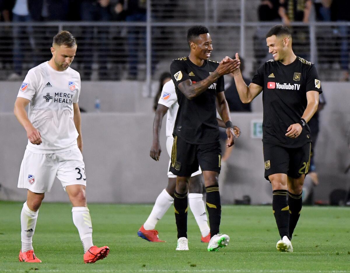 LAFC's Mark-Anthony Kaye (14) celebrates his goal with Christian Ramirez (21) in front of FC Cincinnati's Caleb Stanko (33) to take a 1-0 lead, during the first half at Banc of California Stadium on Saturday.