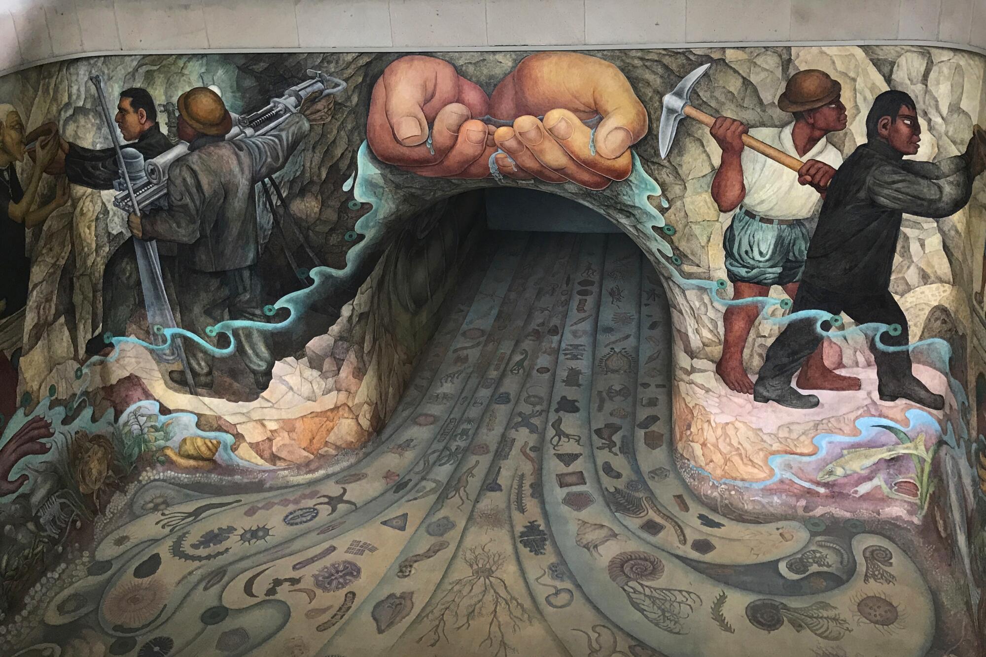 A mural depicts hands cupping water over a tunnel, with images of workers on each side. 