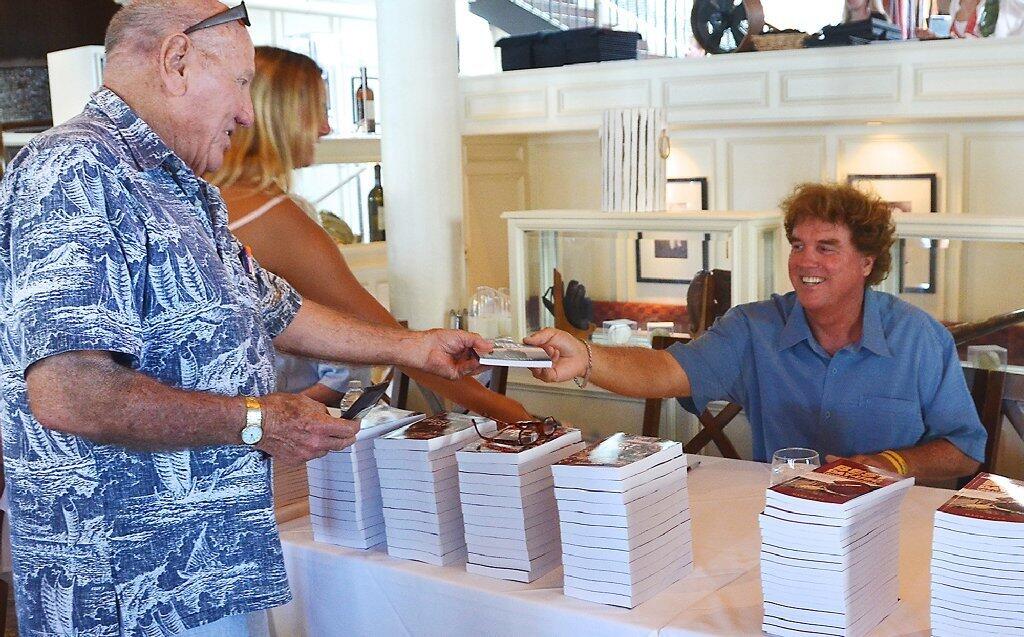 Mark Keys, right, signs a book for Rolly Pulaski during his Best Day book signing held Saturday at The Cannery Restaurant.