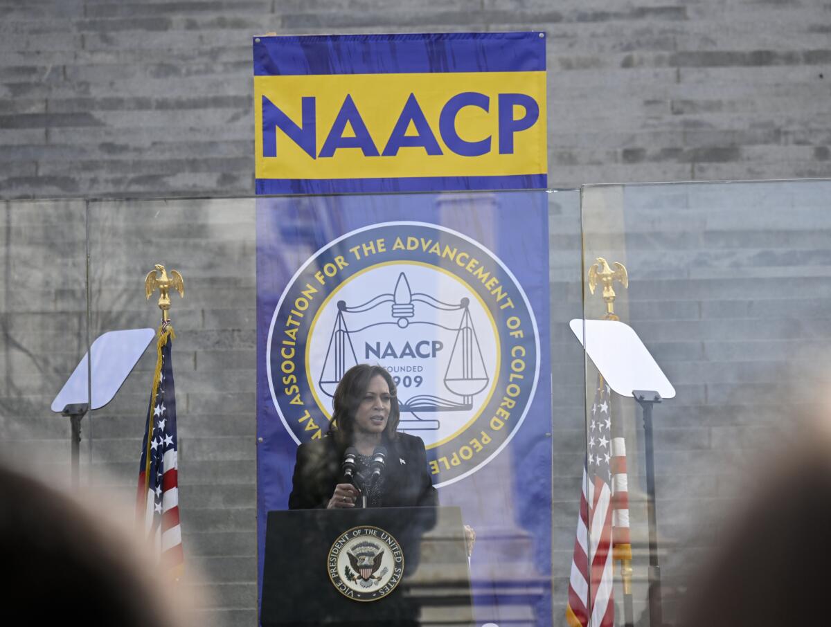 Kamala Harris in front of the State Capitol in Columbia, S.C., under a seal and banner for the NAACP