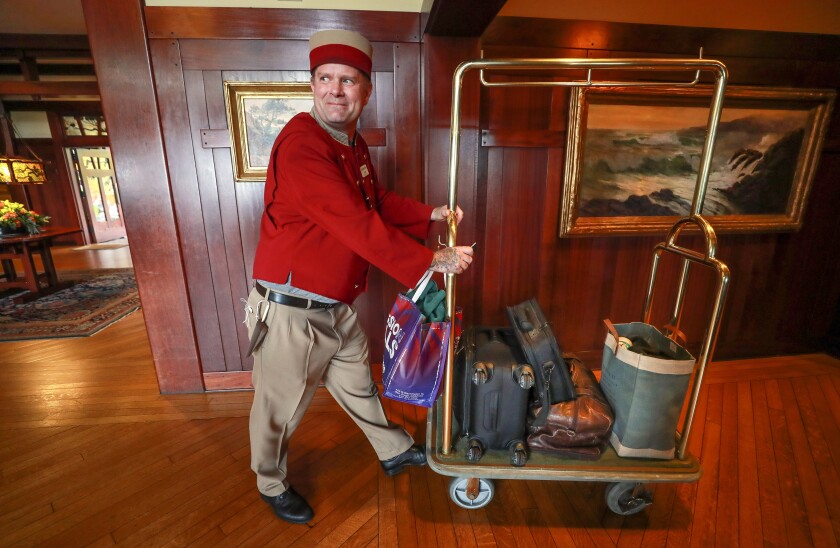 Bellman Justin Davis pushes a cart holding the luggage of a couple from San Diego who are staying at The Lodge at Torrey Pines in La Jolla while their home is being fumigated.