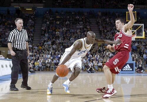 Darren Collison of the UCLA Bruins drives to the basket past Jason Haas of the Stanford Cardinal.